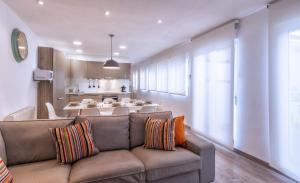 a living room with a couch and a kitchen at Ca La Josefa in Balaguer