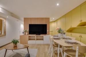 a living room with a table and a television at Basement studio- Montparnasse Station in Paris
