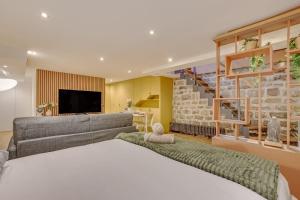 a bedroom with a large bed and a couch at Basement studio- Montparnasse Station in Paris