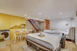 a bedroom with a large bed and a kitchen at Basement studio- Montparnasse Station in Paris +3 photos