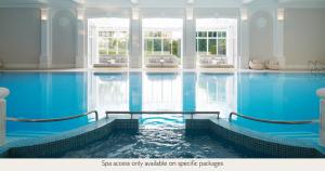 a large indoor swimming pool with blue water at Champneys Henlow in Henlow