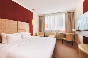 a hotel room with a large bed and a table at Radisson Blu Szczecin in Szczecin +69 photos