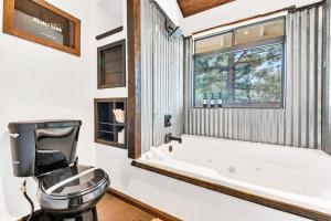 a bathroom with a toilet and a tub and a window at Authentic 4BR Big Bear Cabin, Dog-Friendly with Deck in Big Bear City +62 photos