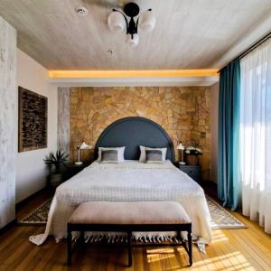 a bedroom with a large bed with a stone wall at Mayachok Boutique hotel in Kyiv
