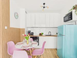 a kitchen with a table with pink chairs and a blue refrigerator at Baltic Horizon Klifowa by Solarento in Rewal +16 photos
