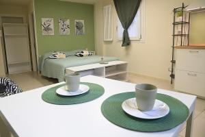 a room with two cups and plates on a table at Volta B&B Imola in Imola