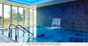 a large indoor pool with blue tiles at Champneys Tring in Tring