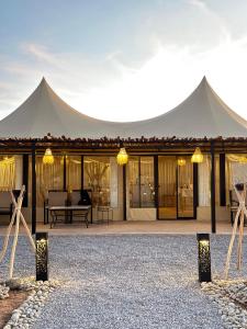 a tent with a table and chairs in front of it at Antares Desert Camp in Merzouga