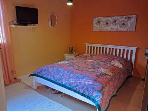 a bedroom with a bed and a tv on the wall at Haus Martina in Siegsdorf