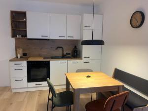 a kitchen with white cabinets and a wooden table at Villa Lidl Ferienwohnung in Altaussee