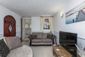 a living room with a couch and a television at Preswylfa in Cemaes Bay