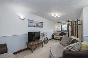 a living room with a couch and a tv at Preswylfa in Cemaes Bay +16 photos