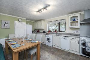 a kitchen with a wooden table with chairs and appliances at Preswylfa in Cemaes Bay