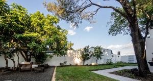 a garden with benches and trees in front of a building at Casa Cielo Cardenal in Concepción del Uruguay +14 photos