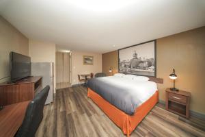 a hotel room with a bed and a flat screen tv at Super 8 by Wyndham Kingston in Kingston