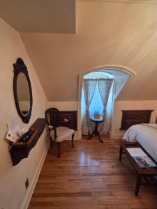 a bedroom with a bed and a mirror and a table at Auberge J.A Moisan in Quebec City