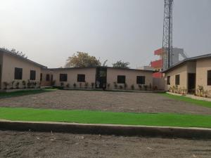 a building with a field of grass in front of it at 7 Vachan Garden and Resort in Bhopal