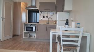 a small kitchen with a table and a microwave at Appartement T2 cosy in Canteleu