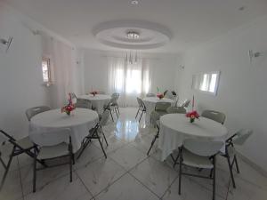 a room with tables and chairs with flowers on them at Résidence Mialy in Manankasina