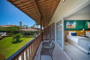 a balcony with a bed and chairs on it at Salinas Maceio All Inclusive Resort in Maceió