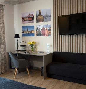 a desk in a room with a couch and a television at Mayachok Boutique hotel in Kyiv