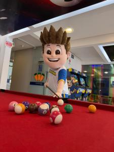 a cartoon man standing in a pool table with balls at Centromar Hotel in Balneário Camboriú