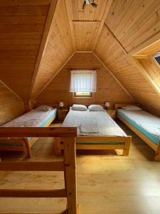 a bedroom with two beds in a wooden cabin at Domki AGA in Mrzeżyno