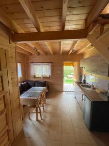 a kitchen with a table and a couch in a room at Domki AGA in Mrzeżyno