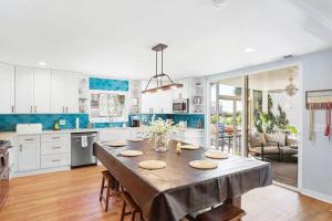 a kitchen with a large wooden table with chairs at Sandy Paws Retreat - 30 Day Rental in Folly Beach