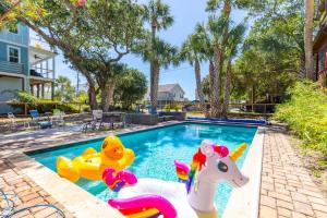 a swimming pool with inflatable toys in a backyard at Sandy Paws Retreat - 30 Day Rental in Folly Beach