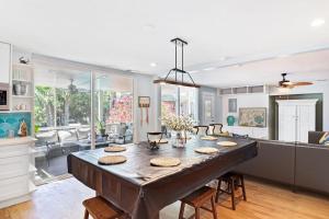 a kitchen and living room with a large wooden table at Sandy Paws Retreat - 30 Day Rental in Folly Beach