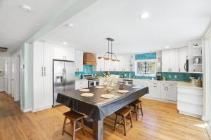 a kitchen with a table with chairs and a refrigerator at Sandy Paws Retreat - 30 Day Rental in Folly Beach +22 photos