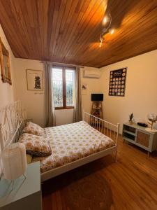 a bedroom with a bed and a wooden ceiling at Les maisons de Gaïa Chambre d'hôte climatisée in Tuchan