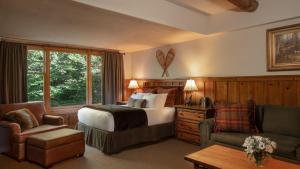 a bedroom with a bed and a chair and a couch at The Whiteface Lodge in Lake Placid