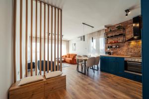 a kitchen and living room with a table and chairs at Zara Garden Apartment in Novi Sad