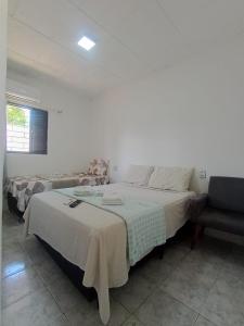 a bedroom with a large bed and a chair at Hotel New in Alegrete