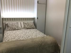 a small bed with a pillow and a window at Puerto playa B in Malpica