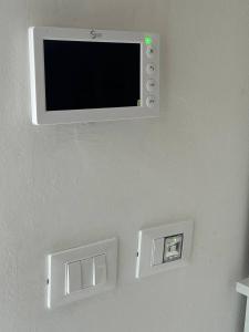a flat screen tv on a wall with two outlets at Le Tre Capanne in Marina di Carrara