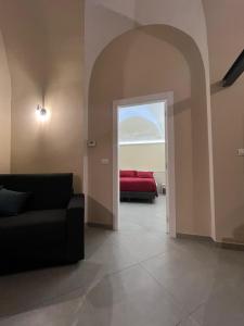 a living room with a red couch and an open door at Il Poggetto Bed and Breakfast in Bovino