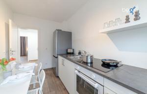 a kitchen with a sink and a refrigerator at BEGE APARTMENTS SmileStay in Gelsenkirchen