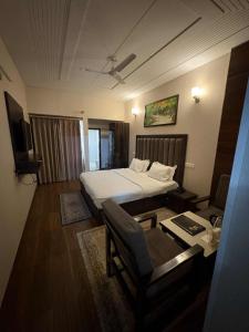 a bedroom with a bed and a desk and a chair at Hotel temple view inn in Anandpur Sāhib
