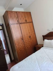 a bedroom with a large wooden cabinet next to a bed at Aster Mekuria in Addis Ababa