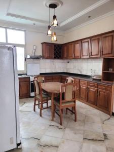 a kitchen with a wooden table and chairs in it at Aster Mekuria in Addis Ababa