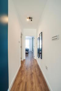 an empty hallway with white walls and wood floors at Zara Garden Apartment in Novi Sad +21 photos