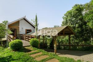 a house with a porch and a wooden deck at Suíte Front Cyclists' Paradise in Gramado