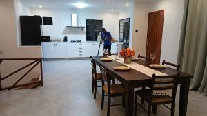 a woman standing in a kitchen with a table at Jacaranda Home in Mbeya