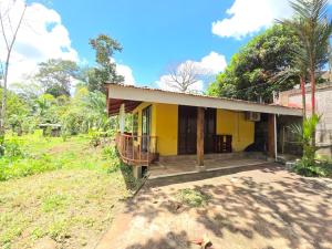 a small yellow house with a porch at Casa Sol in Sarapiquí
