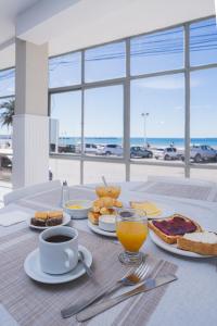 a table with breakfast foods and a cup of coffee at Rayentray Hostal in Puerto Madryn
