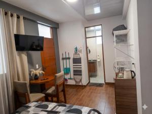 a room with a bed and a table and a desk at Tu Refugio Acogedor a Pasos de Todo in Cochabamba