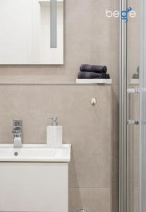 a bathroom with a sink and a mirror and towels at BEGE APARTMENTS SmileStay in Gelsenkirchen